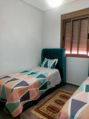 a bedroom with two beds and a window at 2-bedroom apartment in Marrakech