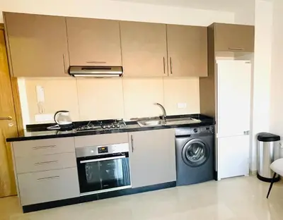 a kitchen with a stove and a washing machine at Cozy appartement à noria golf in Marrakech