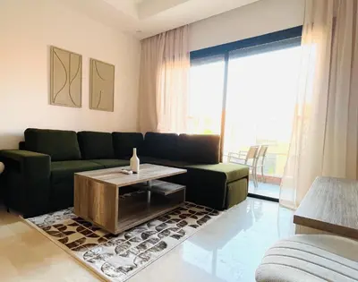 a living room with a couch and a table at Cozy appartement à noria golf in Marrakech