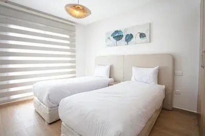 two beds in a white room with white sheets at The Comfort Zone - Private Pool in Marrakech
