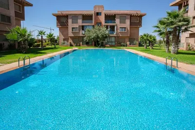 a large blue swimming pool in front of a building at The Comfort Zone - Private Pool in Marrakech