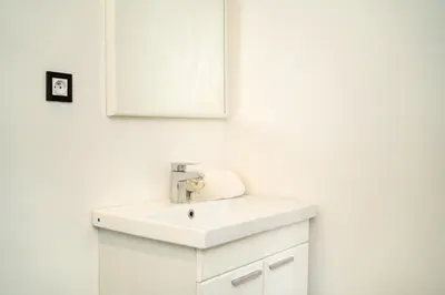 a white bathroom with a sink and a mirror at Cozy apartment in the hypercenter in Marrakech