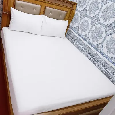 a bed with white sheets and pillows at شقة باب دكالة in Marrakech
