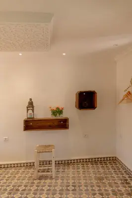 a room with a chair and a tv on a wall at Riad Dar Moulay 120m2 in der Medina mit Terrasse in Marrakech