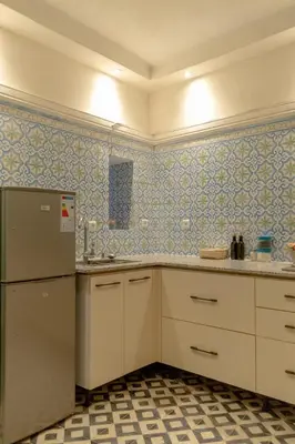 a kitchen with white cabinets and blue tiled walls at Riad Dar Moulay 120m2 in der Medina mit Terrasse in Marrakech