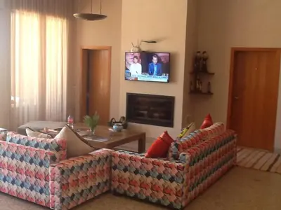 a living room with two couches and a tv on the wall at Domaine VILLA in Marrakech