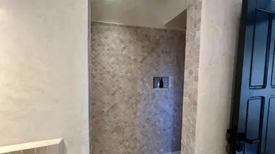 a bathroom with a shower with a blue door at Riad Bergamot in Marrakech