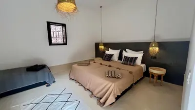 a bedroom with a large bed and a table at Riad Bergamot in Marrakech
