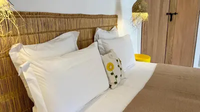 a bed with white sheets and pillows in a room at Riad Bergamot in Marrakech