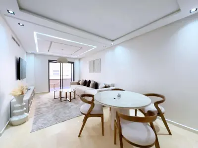 a living room with a table and a couch at Menara Garden Wifi Parking Piscine in Marrakech