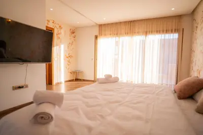 a bedroom with a large white bed with a large window at Villa Akenza - Cinema - Swiming pool in Marrakech
