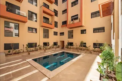 an apartment with a swimming pool in front of a building at Stylish Hivernage Studio in Marrakech