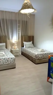 a bedroom with two beds and a chandelier at Two bedroom apartment - Guéliz train station in Marrakech