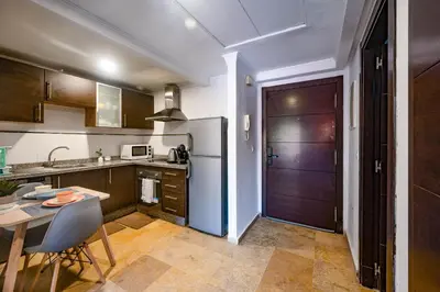 a kitchen with a refrigerator and a table with chairs at Studio cosy avec piscine et balcon Résidence Mirador Majorelle in Marrakech