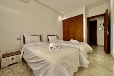 a bedroom with two beds with white comforters at Top floor apartment in Gueliz with Balcony in Marrakech