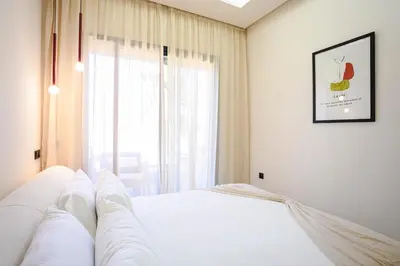 a white bed in a room with a window at Marrakech Éternel - Hivernage in Marrakech