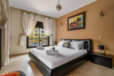 a bedroom with a large bed and a window at Marrakech GUELIZ Vue Imprenable et Terrasse rare in Marrakech
