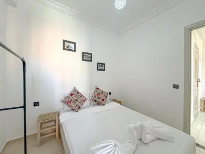 a white bedroom with a bed in a room at Lumière d'Atlas Calme et Confort in Marrakech
