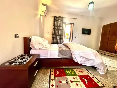 a bedroom with a bed and a table and a rug at Nelbrj Studio in Marrakech