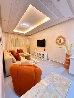 a living room with a couch and a tv at Orange Apartment With Pool in Marrakech