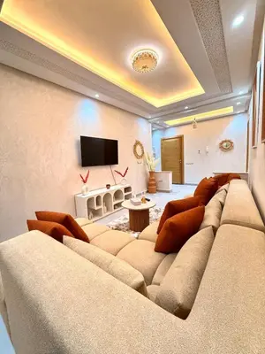 a living room with a large couch and a flat screen tv at Orange Apartment With Pool in Marrakech