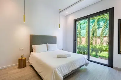 a bedroom with a white bed with a large window at Family villa in Marrakech in Marrakech