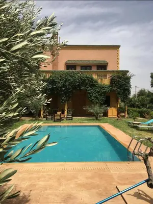 a swimming pool in front of a house at Villa Louise in Marrakech