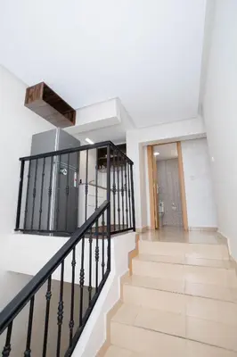 a staircase in a house with white walls and black railings at Bonheur appartement in Marrakech