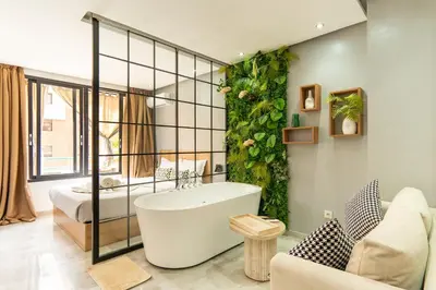 a bathroom with a bath tub and a bedroom at Luxury Balnéo appartement in Marrakech