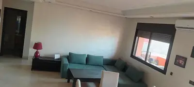 a living room with a green couch and a table at premium village m231 in Marrakech