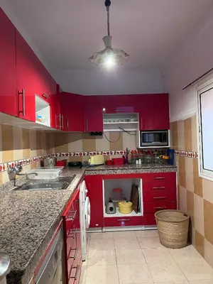 a kitchen with red cabinets and a microwave at Dar MI HNIA in Marrakech