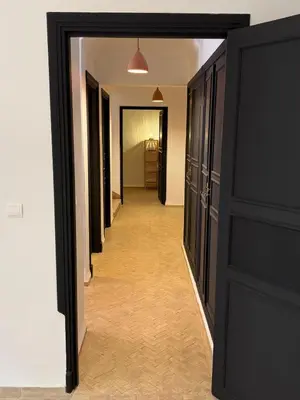 a hallway with black doors and a long corridor at Villa ÈME in Marrakech