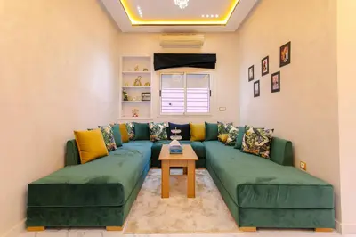 a living room with a green couch and a table at Appartement limoen in Marrakech