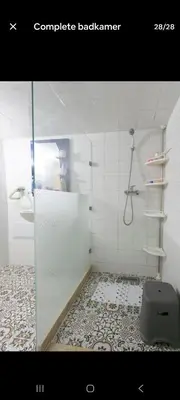 a bathroom with a shower with a glass door at Appartement limoen in Marrakech