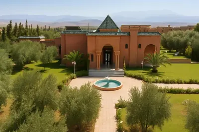 a building with a fountain in front of it at Villa de Charme avec Piscine, Hammam & Jardin Enchanté in Marrakech