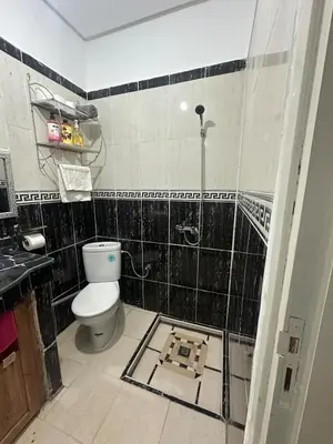 a bathroom with a toilet and a black tiled wall at Modern Comfort, Local Vibes in Marrakech