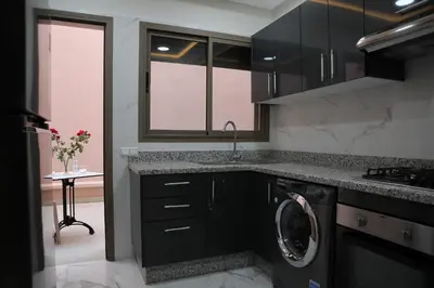 a kitchen with black cabinets and a washer and dryer at Medali in Lahebichate