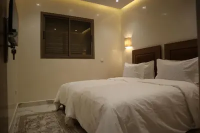 a bedroom with a bed with white sheets and a window at Medali in Lahebichate