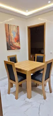a wooden dining room table with two chairs and a painting at Medali in Lahebichate