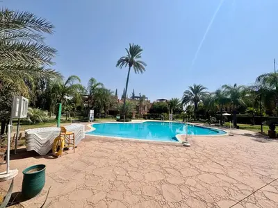 a swimming pool in a resort with palm trees at Private Garden Villa - Rooftop, BBQ, Pools and Views in Marrakech