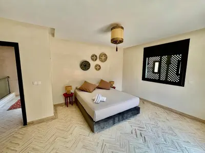 a bedroom with a white bed in a room at Private Garden Villa - Rooftop, BBQ, Pools and Views in Marrakech