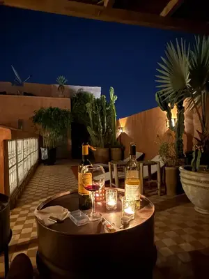 a table with wine bottles and glasses on a patio at PRIVATE HOUSE in Medina Close to Jeema El Fna in Marrakech