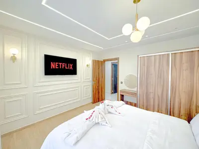 a white bed in a room with a sign on the wall at Perle de Marrakech avec Piscine et Parking in Marrakech