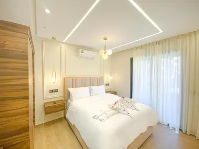a bedroom with a large white bed with slippers on it at Perle de Marrakech avec Piscine et Parking in Marrakech