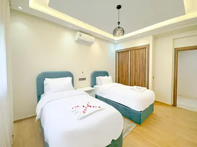 two beds in a room with white sheets at Perle de Marrakech avec Piscine et Parking in Marrakech
