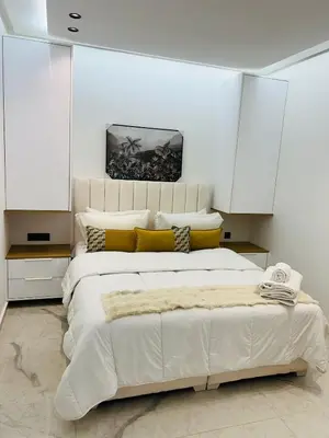 a bedroom with a large white bed with yellow pillows at L'aube de l'éveinage 2 bedrooms Marrakech station in Marrakech