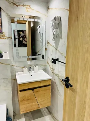 a bathroom with a sink and a mirror at L'aube de l'éveinage 2 bedrooms Marrakech station in Marrakech