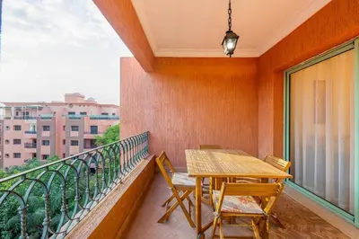 a balcony with a wooden table and chairs at Urban Pearl terrace and pool in Marrakech