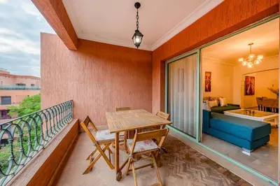 a balcony with a table and chairs and a couch at Urban Pearl terrace and pool in Marrakech
