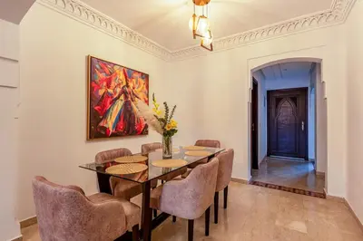 a dining room with a table and chairs and a painting at Urban Pearl terrace and pool in Marrakech